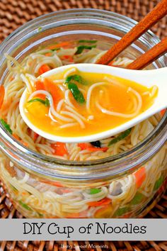 a glass jar filled with noodles and carrots