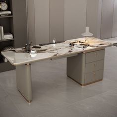 an office desk with marble top and metal legs, in front of bookshelves