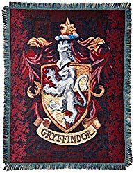 a harry potter tapestry hanging on the side of a wall with hogwarts crest