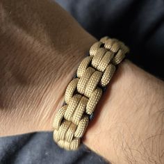 a close up of a person's arm wearing a bracelet with braiding on it