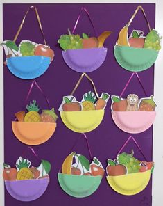 paper plate fruit baskets hanging on a purple wall