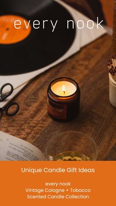 a candle is sitting on a table next to an old record player and some scissors