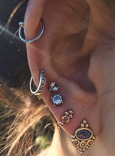 a woman's ear with several piercings attached to it