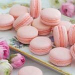 pink macaroons and flowers on a table