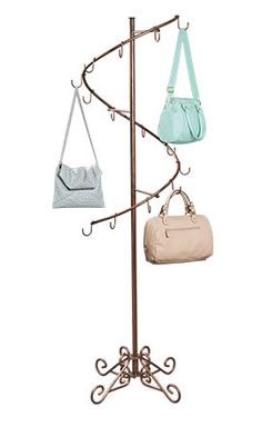 three purses are hanging on a coat rack with two bags attached to the hooks