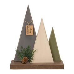 three wooden christmas trees with pine cones on the top and one has a tag hanging from it