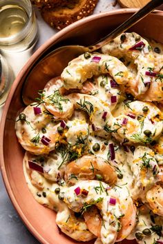 a bowl filled with shrimp and sauce next to bread