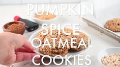 a hand is picking up some oatmeal cookies from a white plate with the words pumpkin spice oatmeal cookies on it