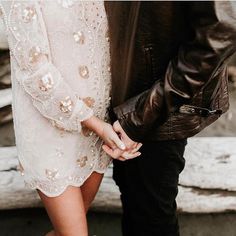 a black and white photo of a man and woman holding each other's hands