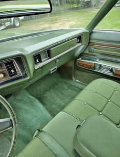 the interior of an old car with green carpet