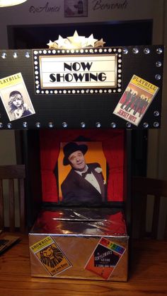 an old fashioned show booth with posters on the front and sides, including a man in a top hat