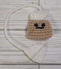 a crocheted bag with a small face on it's side hanging from a string