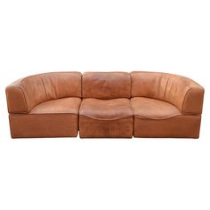 a large brown leather couch sitting on top of a white floor