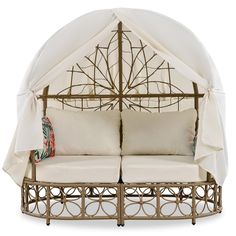 a white canopy bed with two pillows on it's sides and an umbrella over the top