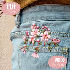 the back pocket of someone's jeans with embroidered flowers on them