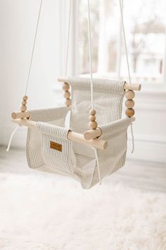 a baby swing with wooden beads hanging from it