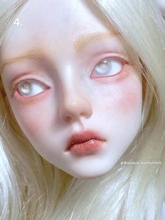 a white doll with long blonde hair and blue eyes