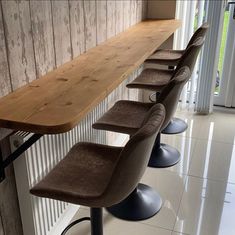 a row of chairs sitting next to a wooden counter