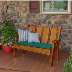 a wooden bench sitting on top of a hard wood floor next to a potted plant