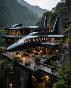 two jet like houses on top of a cliff in the middle of trees and mountains