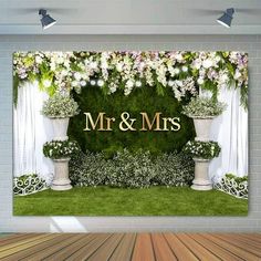 a wedding backdrop with flowers and greenery