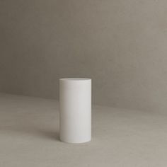 a white vase sitting on top of a table