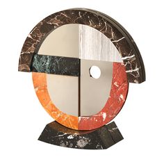 a sculpture made out of marble and wood with an orange, black, white and red circle