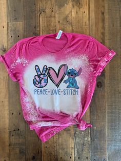 a pink shirt with peace love stitch on it