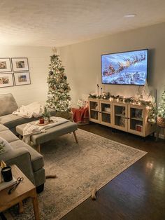 a living room filled with furniture and a christmas tree in front of a flat screen tv