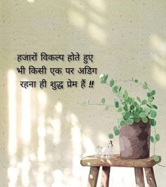 a wooden stool with a potted plant on top of it in front of a wall