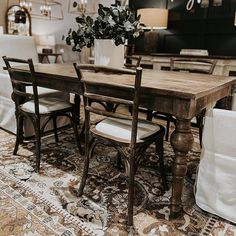 a dining room table with chairs and a vase filled with flowers