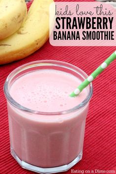 a pink smoothie in a glass with a green and white straw