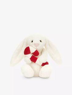 a white stuffed rabbit with a red scarf around its neck sitting against a white background