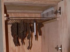 an open cupboard with several pieces of meat hanging from it