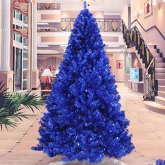 a blue christmas tree in the middle of a lobby