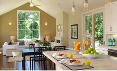 an open concept kitchen and living room with breakfast food on the counter, dining area in the background