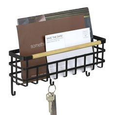 a black metal rack with keys and magazines on it, holding several folders in the same holder