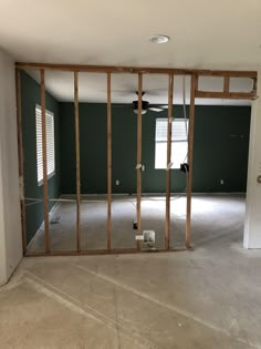 an empty room with green walls and wooden framing