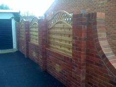 a brick wall with a wooden fence and gate