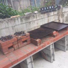 an outdoor bbq grill sitting on top of a red brick wall next to other bricks