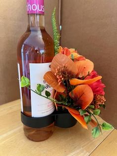 a bottle of alcohol and flowers on a table