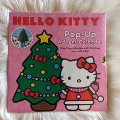 the hello kitty pop - up calendar is in front of a christmas tree and snowflakes