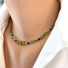 "This dainty peridot and lapis lazuli beaded short necklace is a charming piece of jewelry that effortlessly combines the allure of nature's gemstones with delicate craftsmanship. It can be worn as a stylish accessory for both casual and formal occasions, adding a touch of elegance and sophistication to any outfit. The necklace features a series of small, faceted peridot oval beads and lapis lazuli beads.  The peridot beads are known for their enchanting light green hue, reminiscent of fresh spring leaves. Their sparkling facets catch the light, adding a subtle shimmer to the necklace. These peridot beads are interspersed with lapis lazuli beads, which display a captivating deep blue color reminiscent of the night sky. The lapis lazuli beads have a rich, velvety appearance and may contain Short Necklace Gold, Small Pearl Necklace, Lapis And Peridot, Tiny Necklace, Blue Beaded Necklace, Lapis Lazuli Beads, Oval Beads, August Birthstone, August Birth Stone