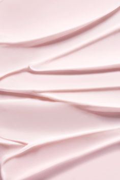 a close up view of some white sheets on a pink sheeted bed coverlet