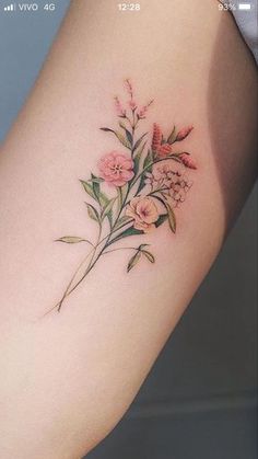 a small flower tattoo on the right side of the leg, with pink flowers and green leaves