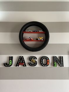 the name mason spelled with toy cars in front of a gray and white striped wall