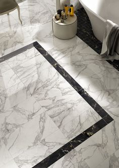 a bathroom with marble flooring and white bathtub in the corner, next to a tub