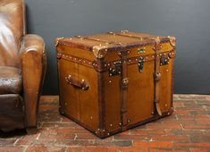 an old trunk sitting next to a leather chair