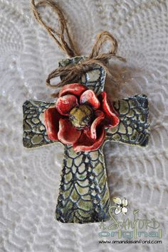 a cross with a red flower on it