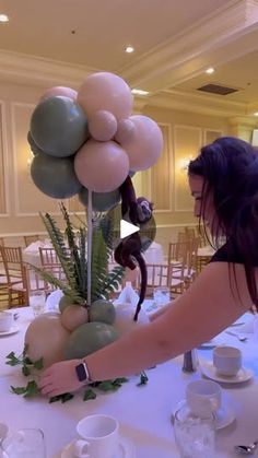 a woman arranging balloons on top of a table